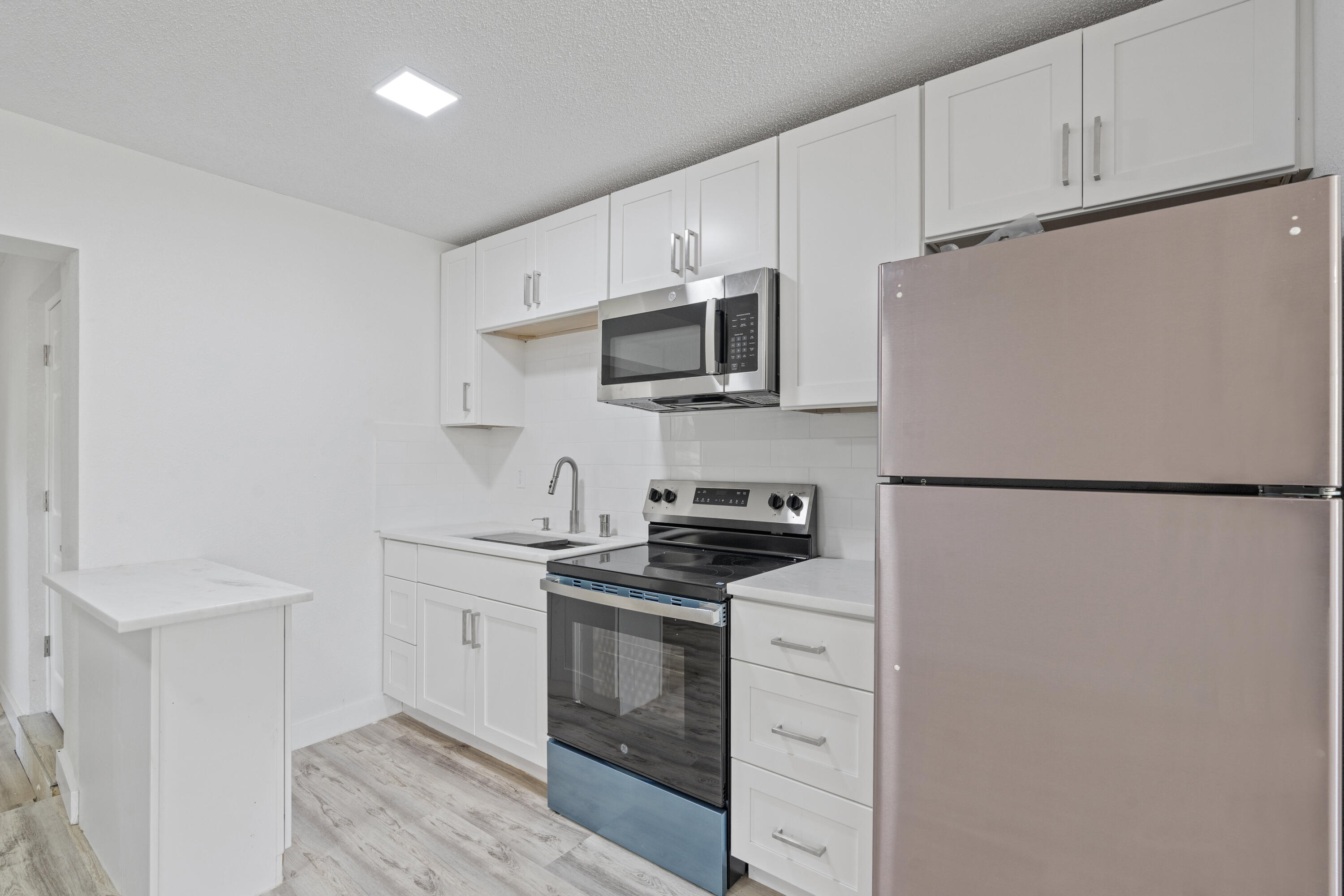 662 Granada Street Fort Pierce, FL 34949 - Photo 13 of 48 a kitchen with stainless steel appliances white cabinets and a refrigerator