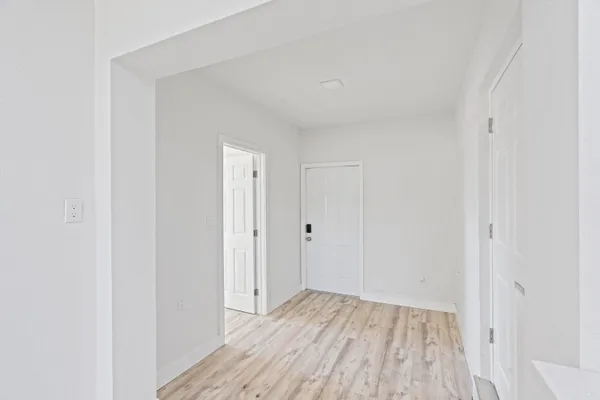 a view of a room with wooden floor and a hallway