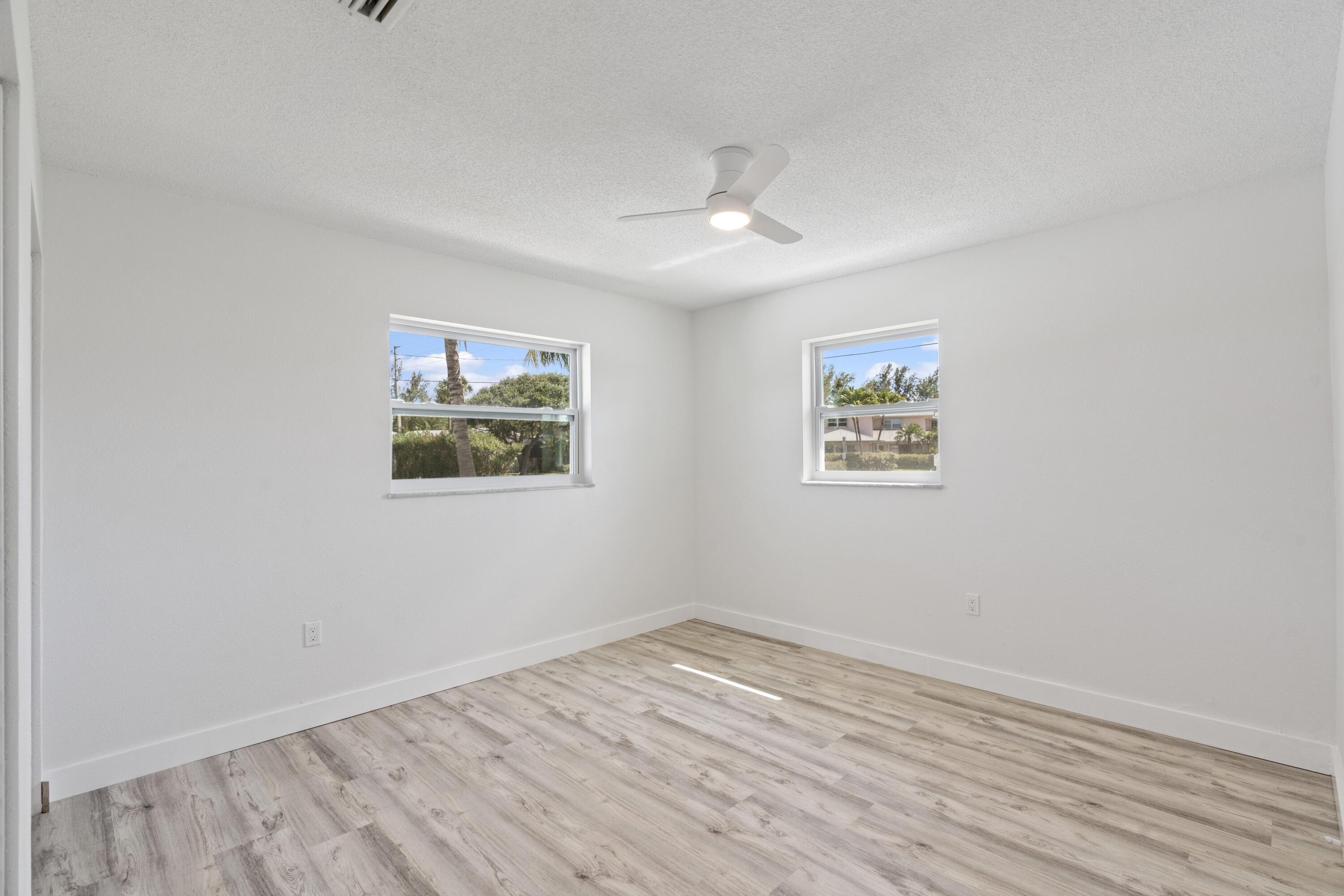 662 Granada Street Fort Pierce, FL 34949 - Photo 16 of 48 an empty room with wooden floor ceiling fan and windows