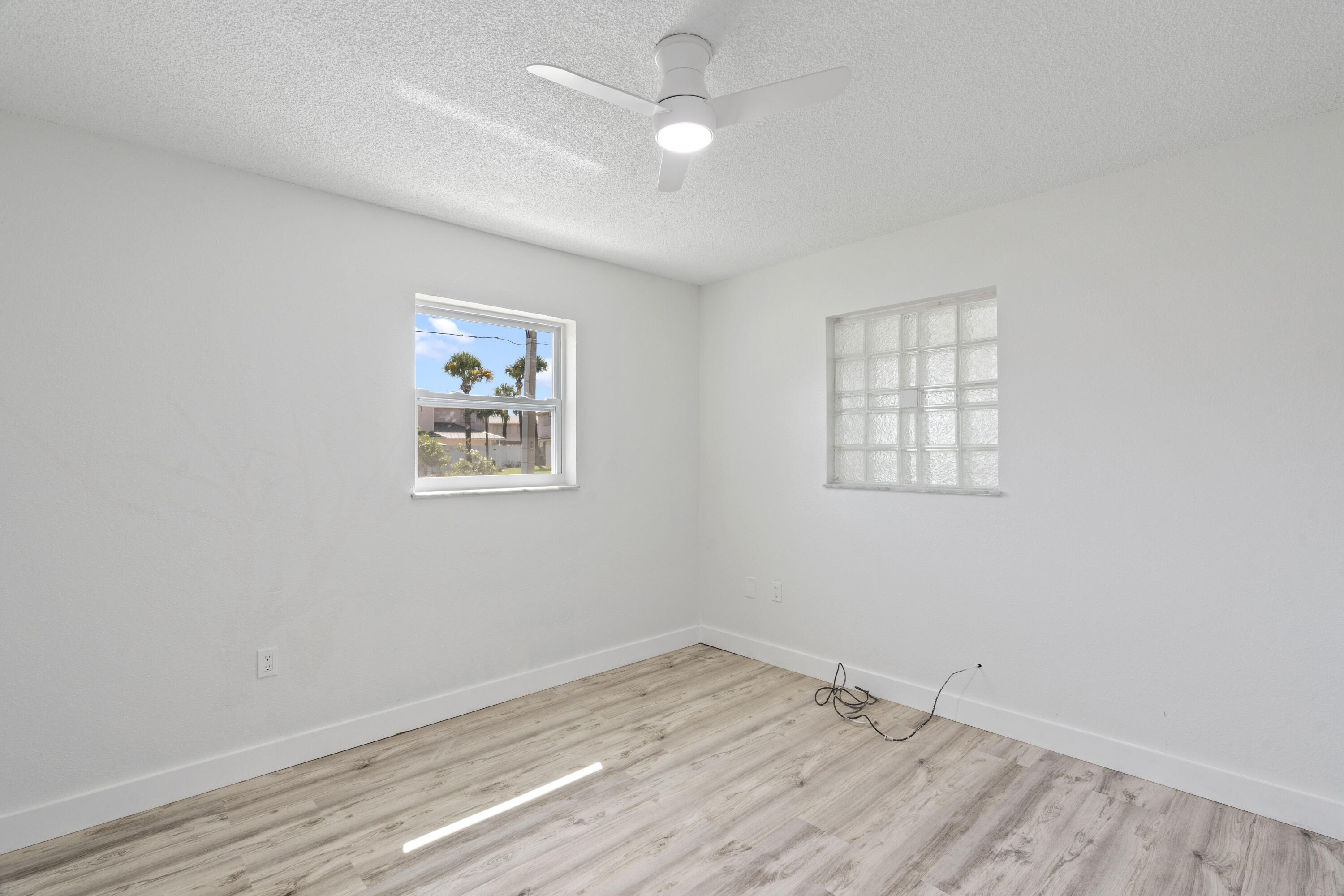 662 Granada Street Fort Pierce, FL 34949 - Photo 18 of 48 an empty room with wooden floor ceiling fan and windows