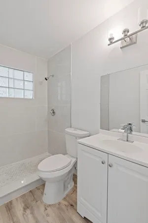 a bathroom with a sink a toilet and shower