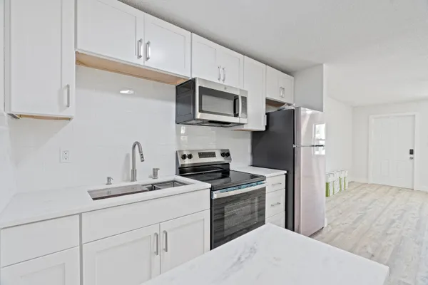 a kitchen with stainless steel appliances a refrigerator sink and microwave