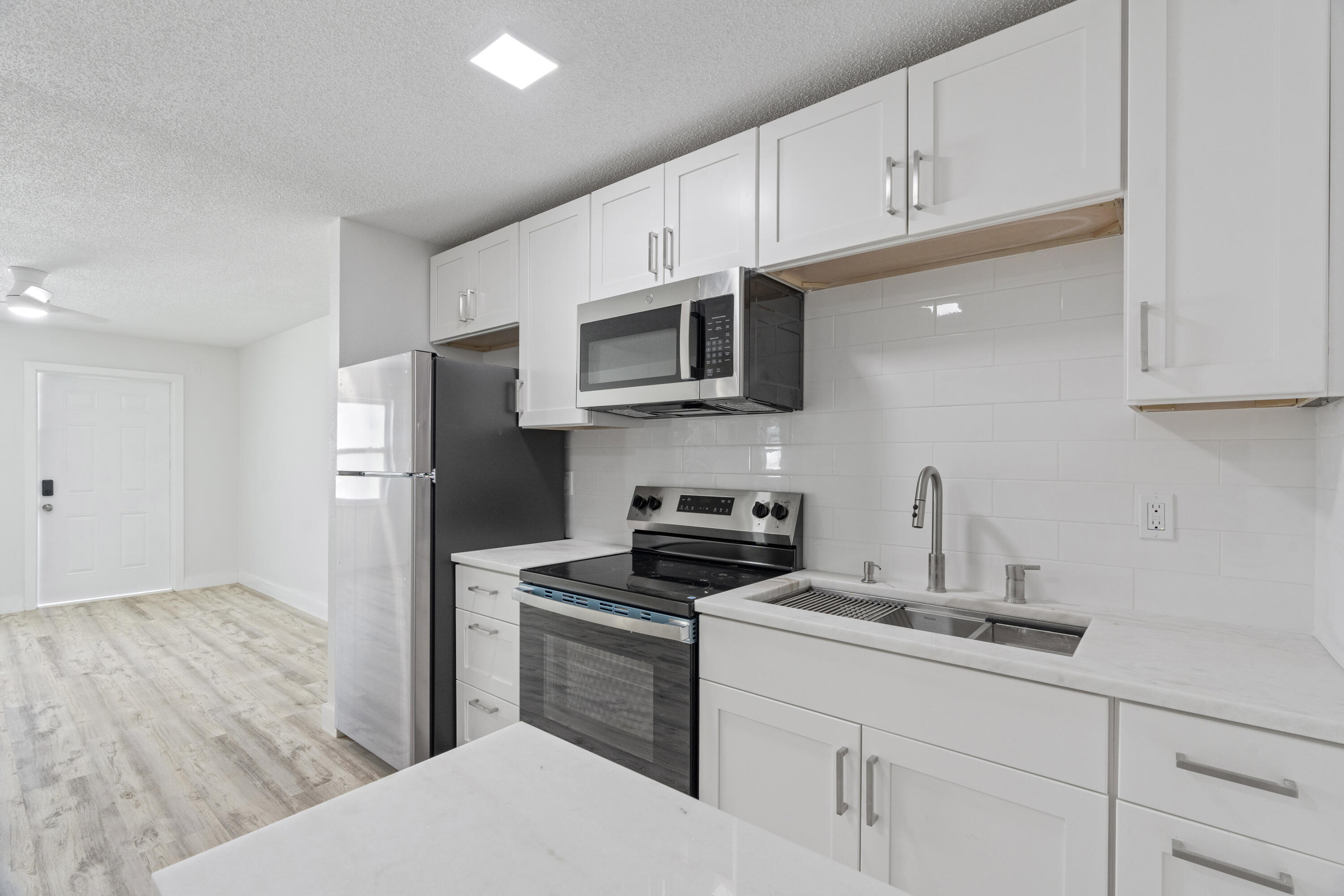 662 Granada Street Fort Pierce, FL 34949 - Photo 27 of 48 a kitchen with stainless steel appliances a sink a stove a microwave a refrigerator a sink and cabinets