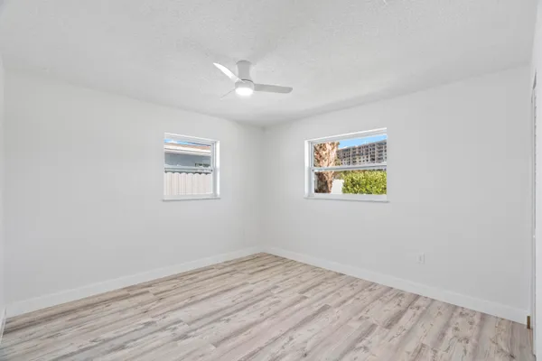 an empty room with wooden floor and window