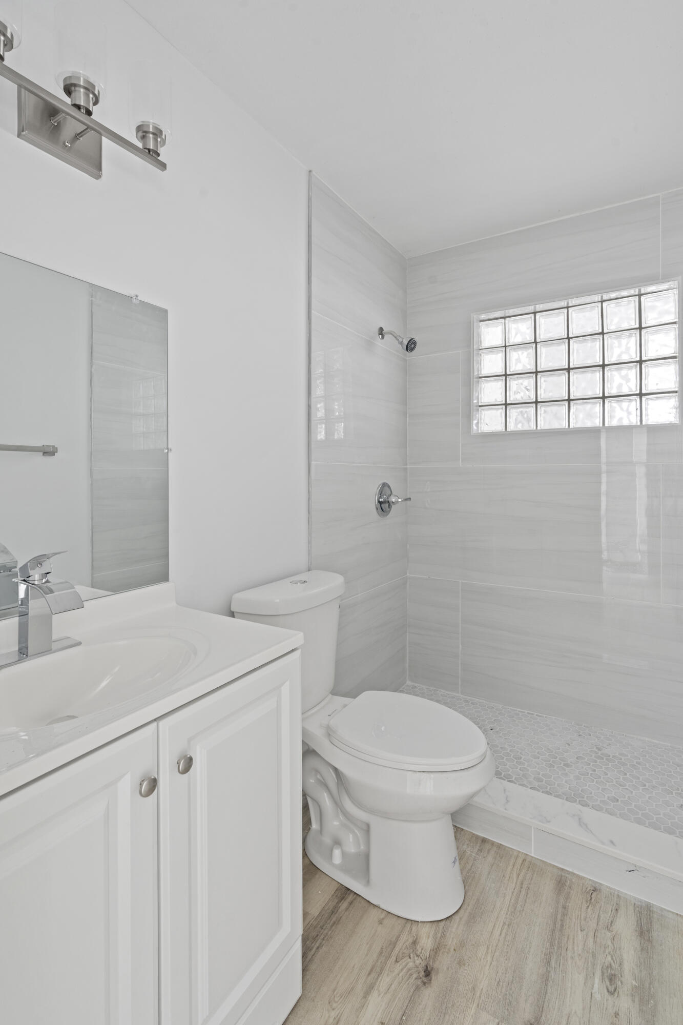 662 Granada Street Fort Pierce, FL 34949 - Photo 34 of 48 a bathroom with a granite countertop sink a toilet a mirror and shower