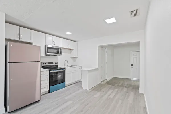 a kitchen with stainless steel appliances a refrigerator sink and microwave