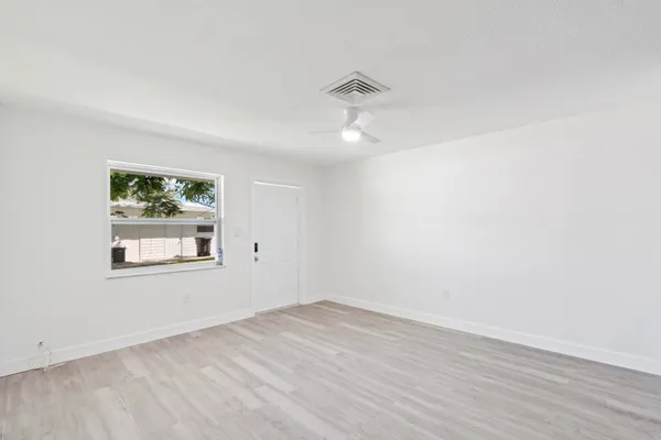 wooden floor in an empty room with a window