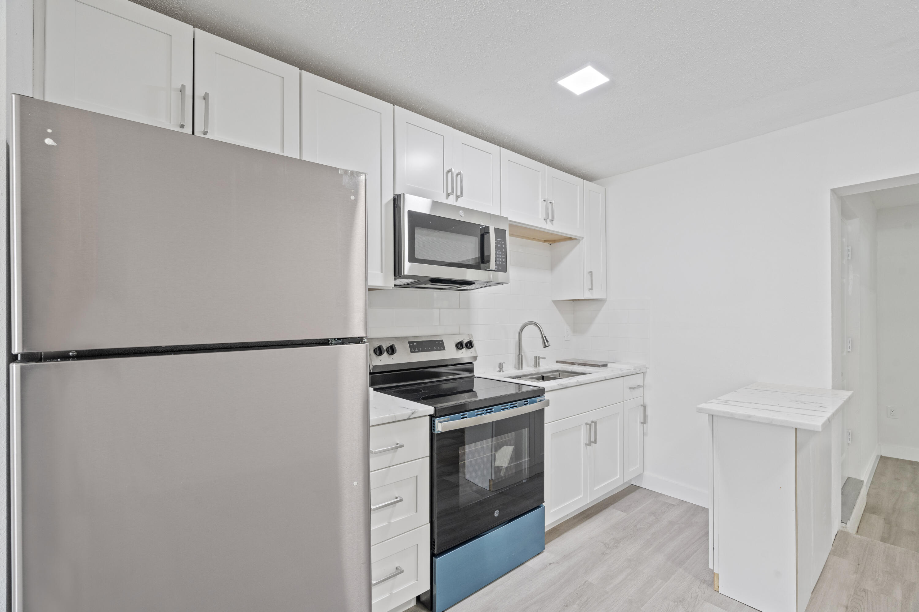 662 Granada Street Fort Pierce, FL 34949 - Photo 41 of 48 a kitchen with stainless steel appliances white cabinets and a refrigerator