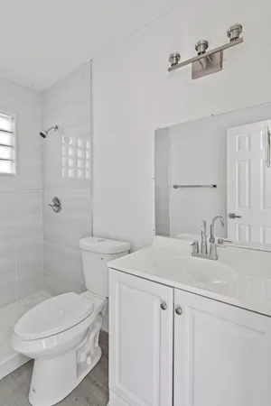 a bathroom with a sink a toilet and shower