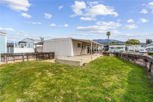 a view of a swimming pool with a patio and a yard