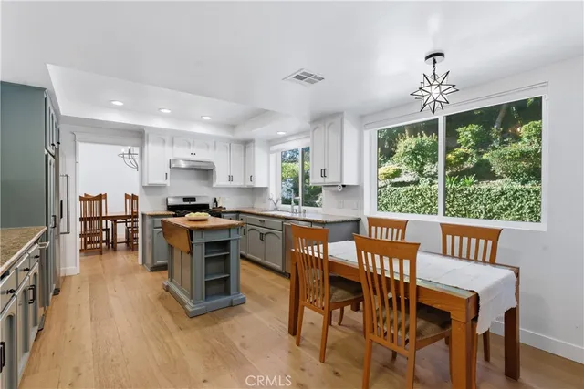 a kitchen with kitchen island a large counter top space appliances and a center island