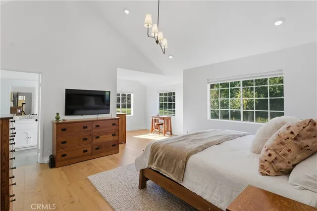 a spacious bedroom with a bed and a flat screen tv