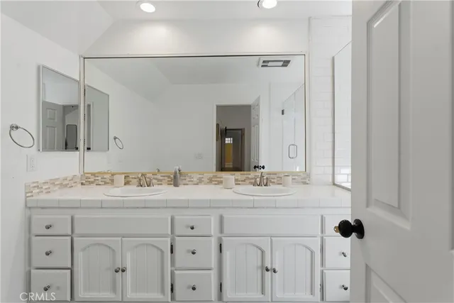 a bathroom with a sink vanity granite and a mirror