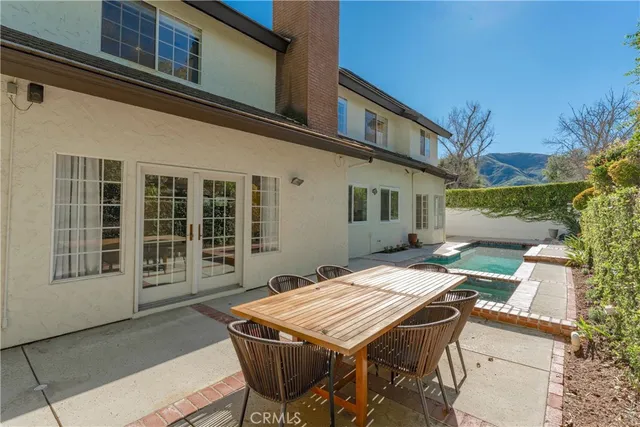 a view of a patio with table and chairs with wooden floor and fence