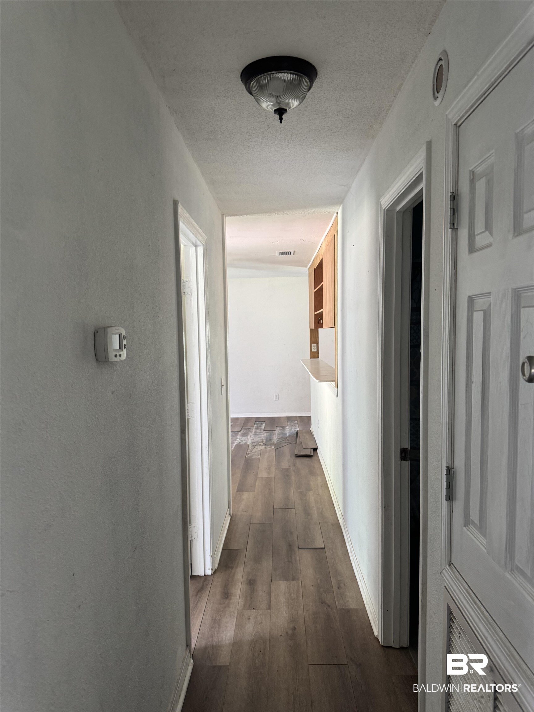 258 Johnson And Spotts Road Deer Park, AL 36529 - Photo 13 of 14 Hall with dark wood-style flooring, a textured ceiling, and baseboards