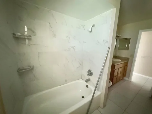 a bathroom with a tub a sink and a shower