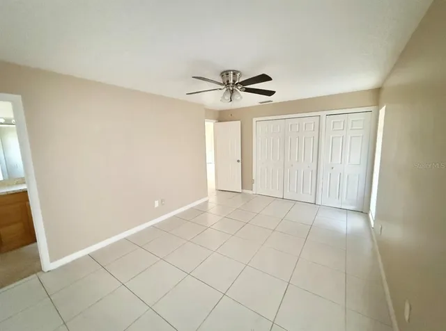a view of an empty room and chandelier fan