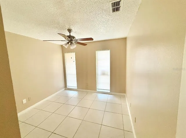 a view of a livingroom with a chandelier fan and windows