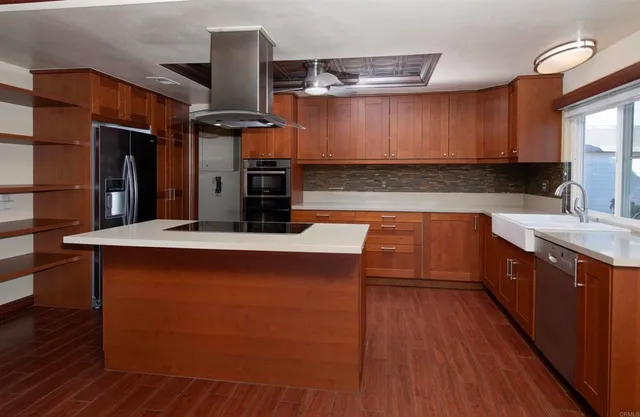 a kitchen with stainless steel appliances wooden cabinets a stove top oven a sink and dishwasher