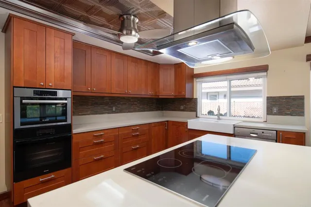a kitchen with stainless steel appliances kitchen island granite countertop a sink stove and cabinets