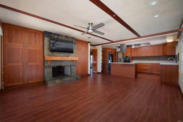 a living room with stainless steel appliances furniture and a flat screen tv