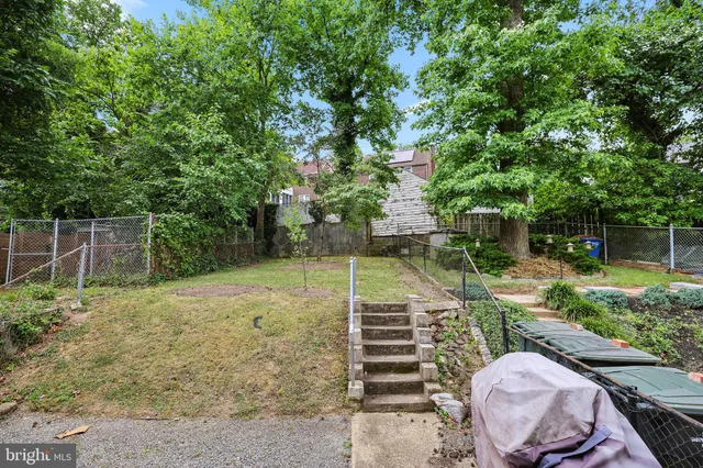 a backyard of a house with lots of plants and tree