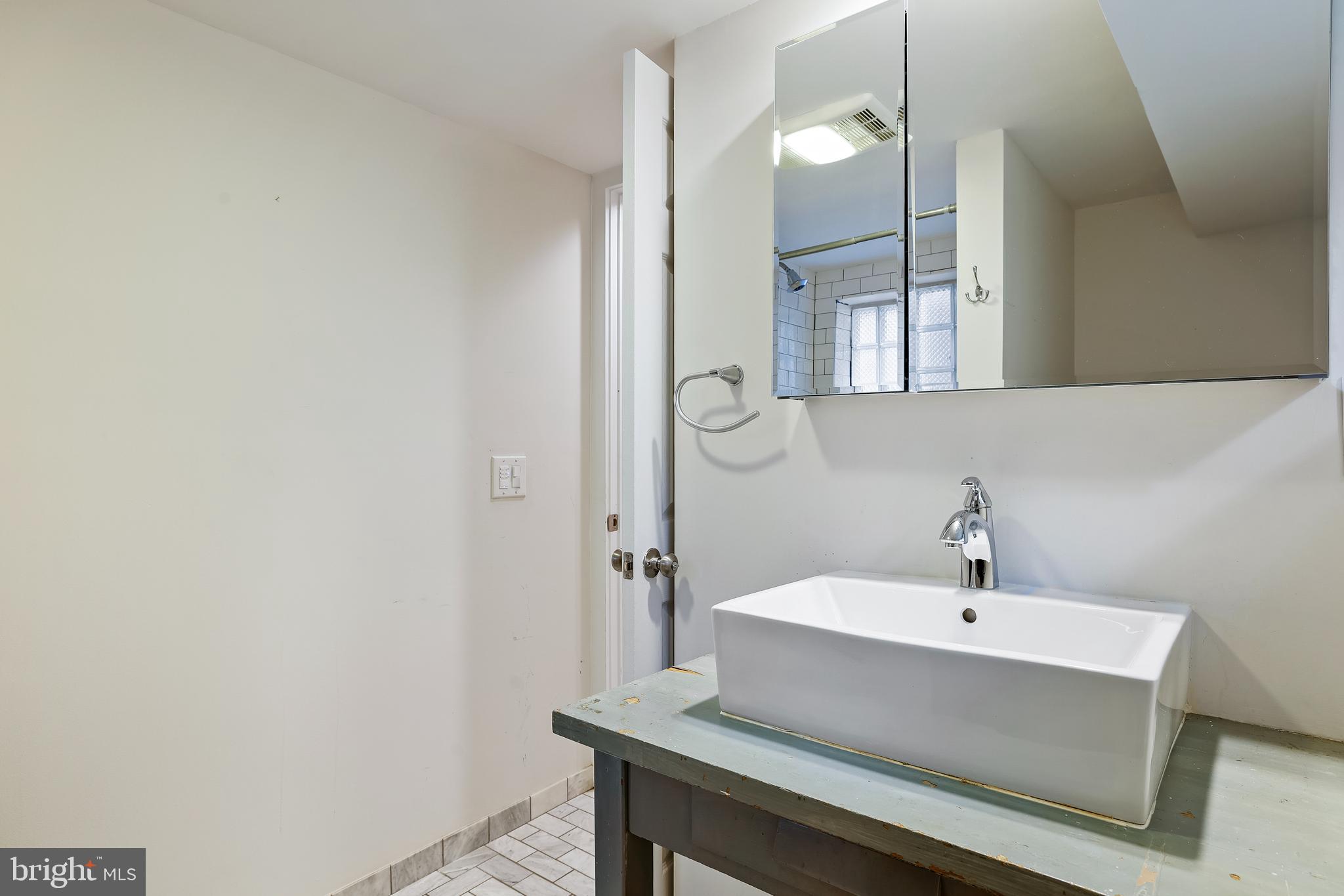 3429 Carpenter Street Southeast Washington, DC 20020 - Photo 19 of 27 a bathroom with a sink a mirror and a shower