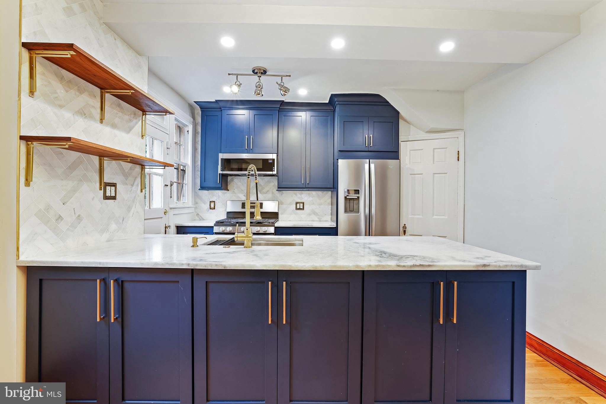 3429 Carpenter Street Southeast Washington, DC 20020 - Photo 7 of 27 a kitchen with kitchen island granite countertop wooden cabinets and refrigerator
