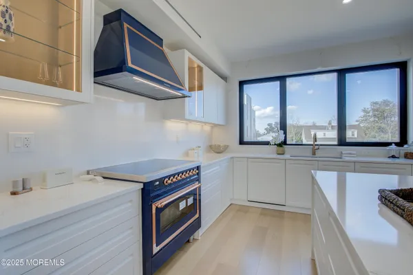 a kitchen that has a sink a stove and cabinets