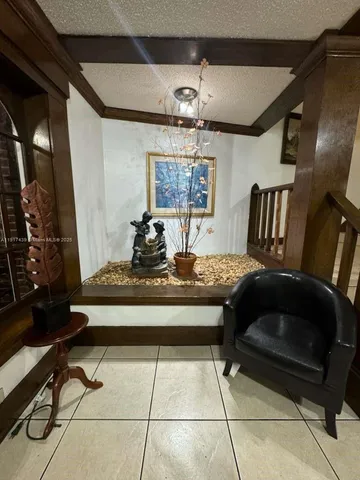 a living room with a table chairs and a chandelier