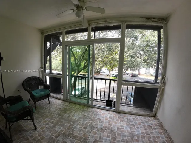 a view of empty room with floor to ceiling window and wooden floor