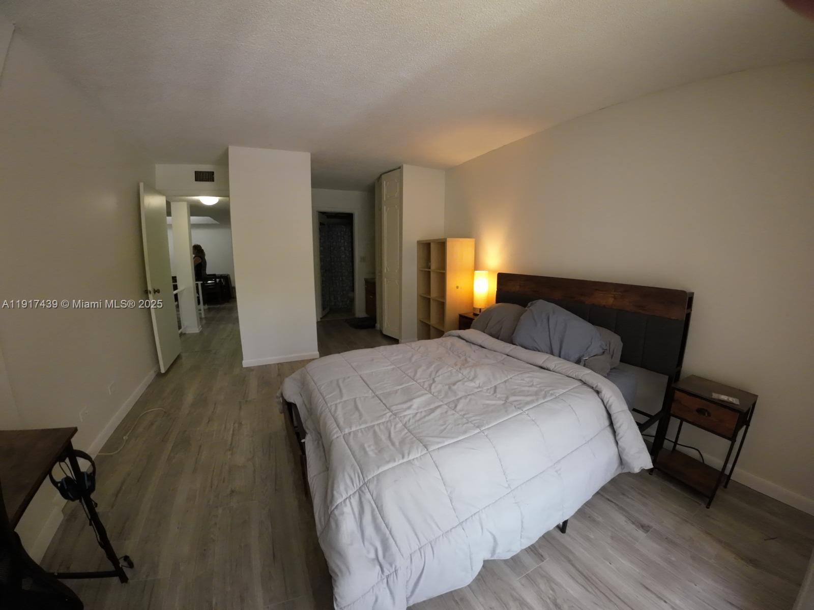 3730 Inverrary Drive, Unit 3U Lauderhill, FL 33319 - Photo 8 of 37 a bedroom with a bed and a mirror