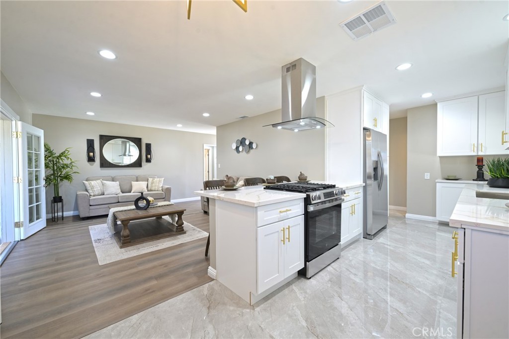 10028 Mildred Court Riverside, CA 92503 - Photo 9 of 50 a large white kitchen with lots of counter space a sink and stainless steel appliances