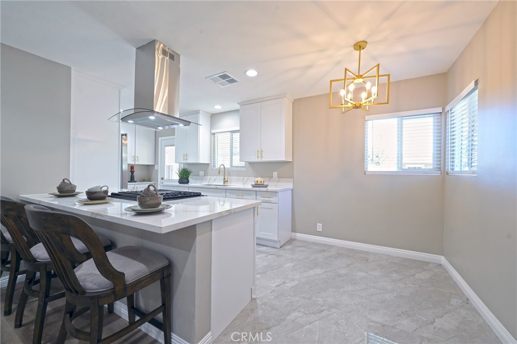 10028 Mildred Court Riverside, CA 92503 - Photo 10 of 50 a kitchen with cabinets a counter space and a chandelier