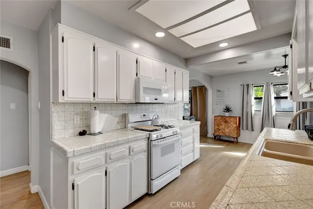a kitchen with stainless steel appliances granite countertop a sink stove and cabinets