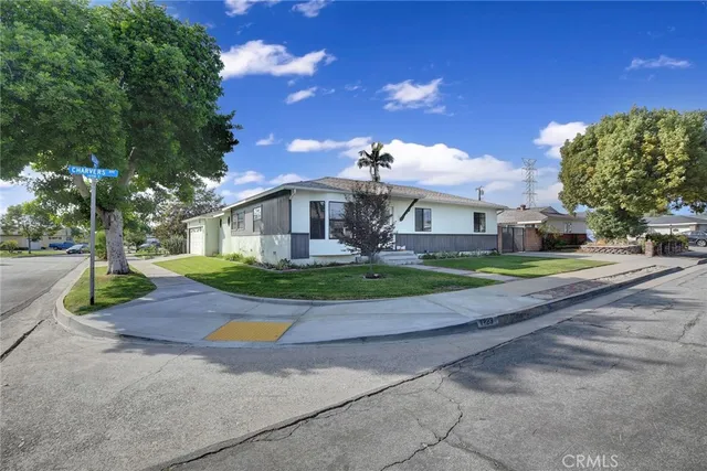 a view of house with yard outdoor seating and covered with tree in back
