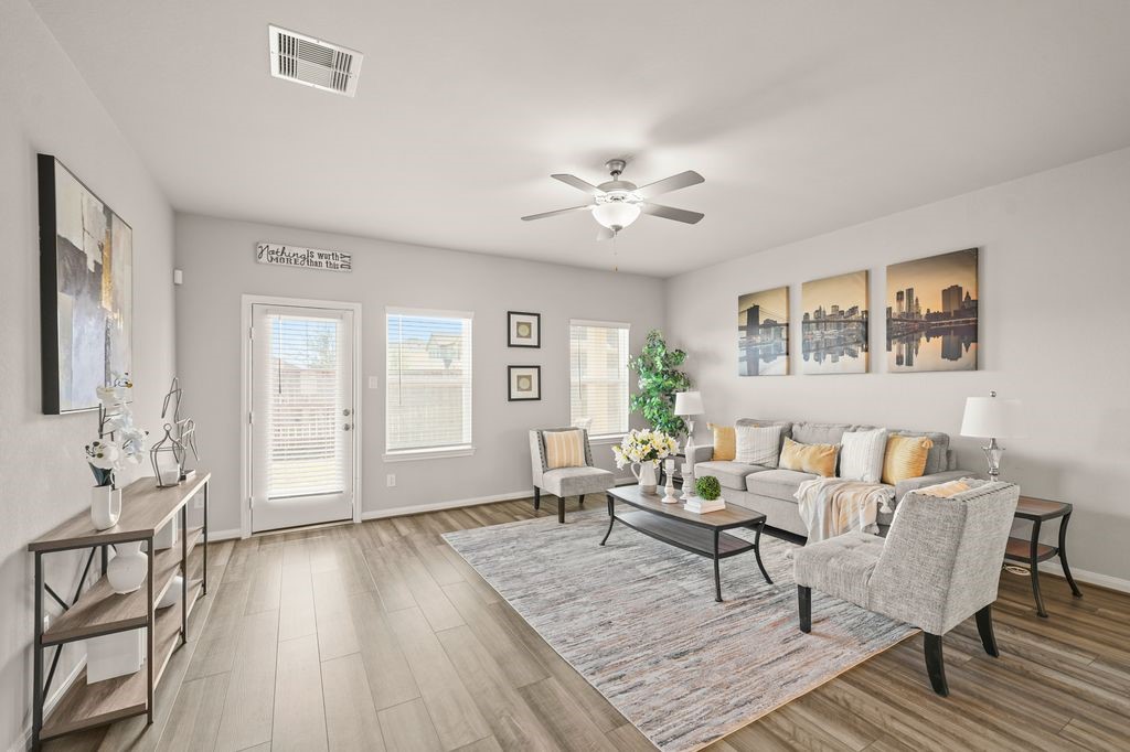 21727 Reserve Ranch Trail Richmond, TX 77407 - Photo 4 of 27 Inviting living area with stylish light fixtures, ample seating space, and direct views into the dining area—perfect for hosting. (Virtually Staged)