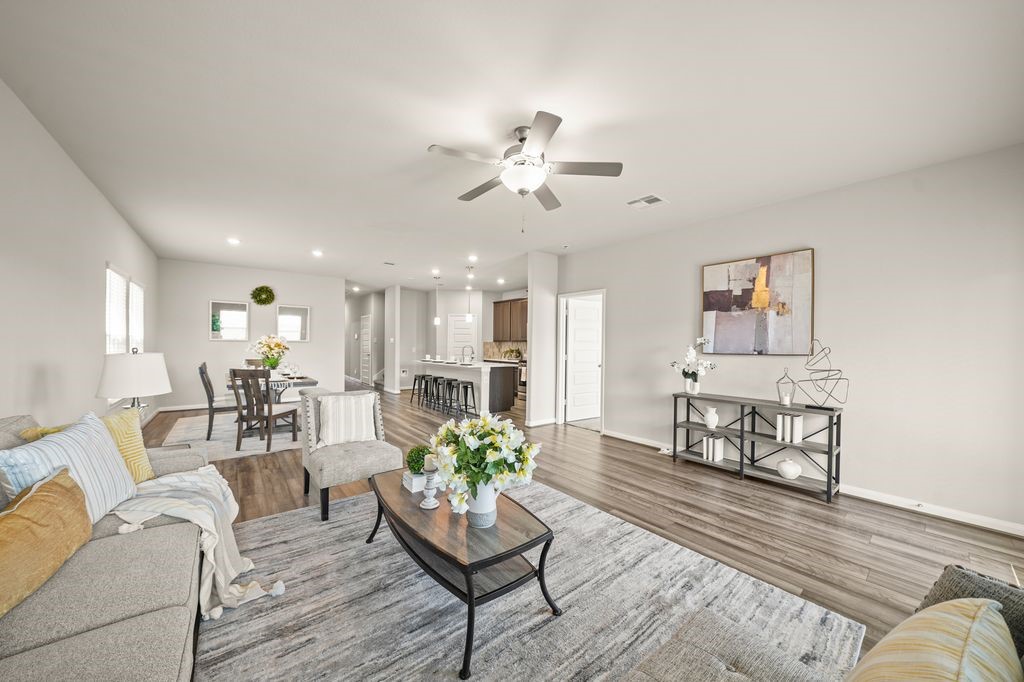 21727 Reserve Ranch Trail Richmond, TX 77407 - Photo 5 of 27 Light-filled living room features large windows, a ceiling fan, and a cozy layout ideal for relaxing or entertaining guests. (Virtually Staged)