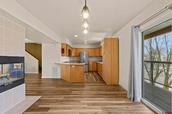 a view of an empty room with window and a chandelier fan