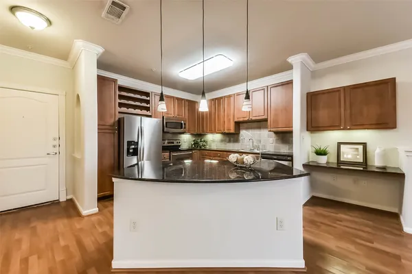 a large kitchen with stainless steel appliances granite countertop a sink a stove and a refrigerator