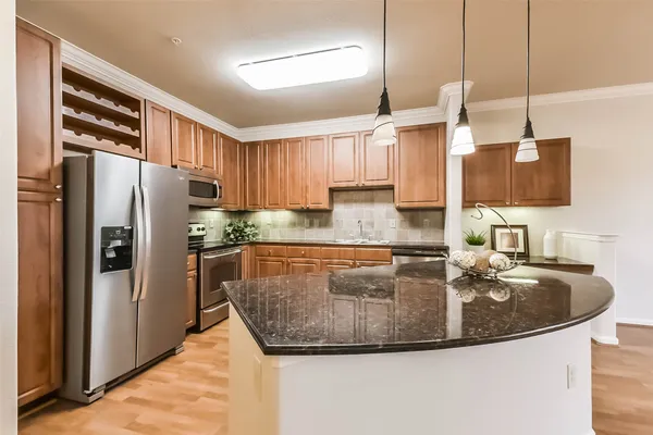 a kitchen with stainless steel appliances granite countertop a sink a refrigerator and a stove
