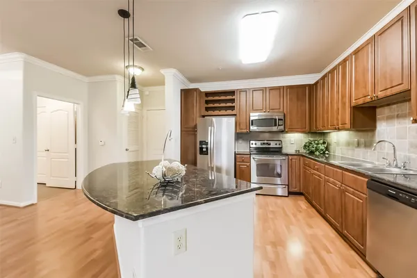 a kitchen with stainless steel appliances granite countertop a sink refrigerator and cabinets