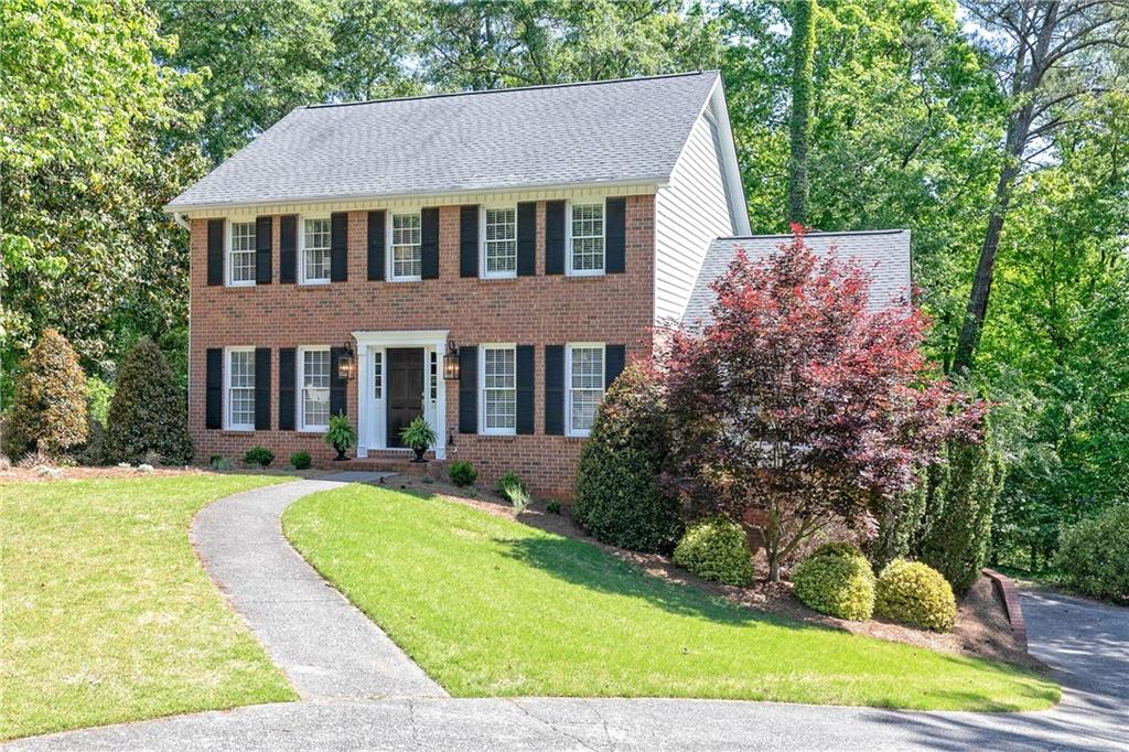 a front view of a house with yard and green space