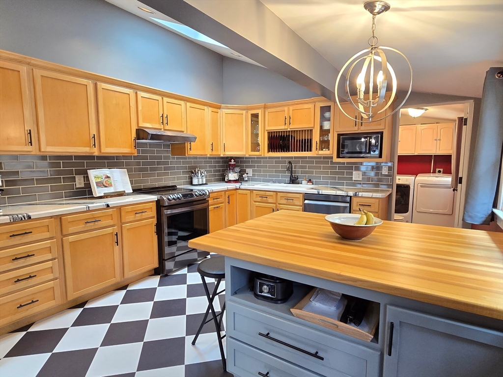33 Pine Hill Road Ashland, MA 01721 - Photo 22 of 40 a kitchen with stainless steel appliances granite countertop a sink a stove and a wooden floors