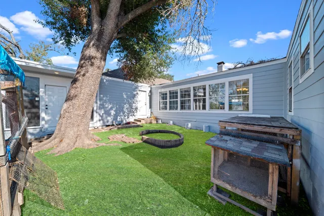 a view of an empty room with a fireplace and a ceiling fan