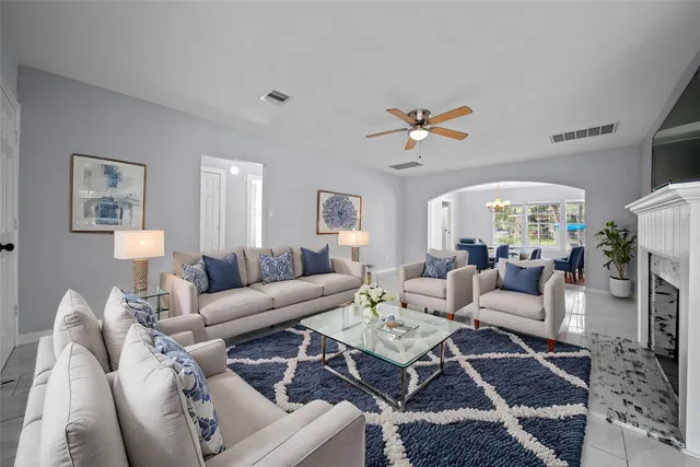 a living room with furniture a chandelier and a rug