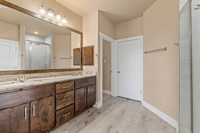 a bathroom with a granite countertop double vanity sink and a mirror
