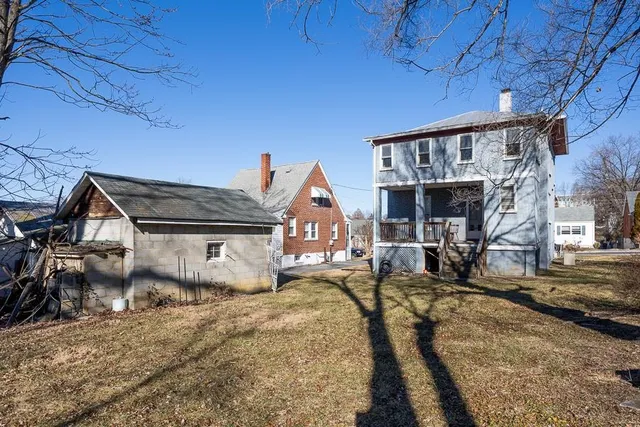 a view of a white house with a yard covered in snow