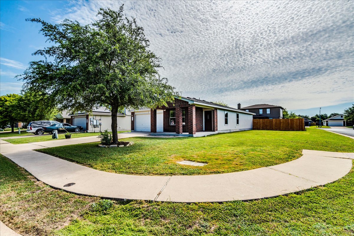 100 Easy Street Hutto, TX 78634 - Photo 36 of 36 A well-maintained lawn embraces a charming single-story residence with a classic brick facade.