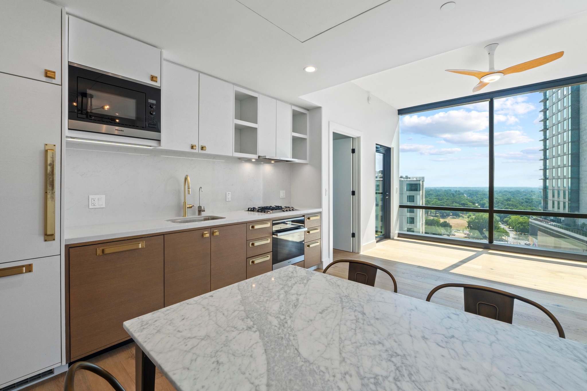 70 Rainey Street, Unit 1303 Austin, TX 78701 - Photo 6 of 31 Modern two-tone cabinetry with built-in dishwasher and refrigerator behind matching cabinet doors.